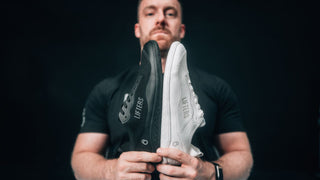 Athlet präsentiert die Bare One Barfußschuhe für Herren in schwarz und weiß