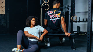 Frau sitzt mit dem neuen Lift More Sport Crop Top auf dem Trainingsboden und schaut in die Kamera